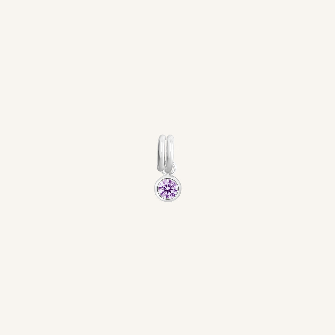 Round silver charm with bezel-set amethyst cubic zirconia representing the February birthstone.