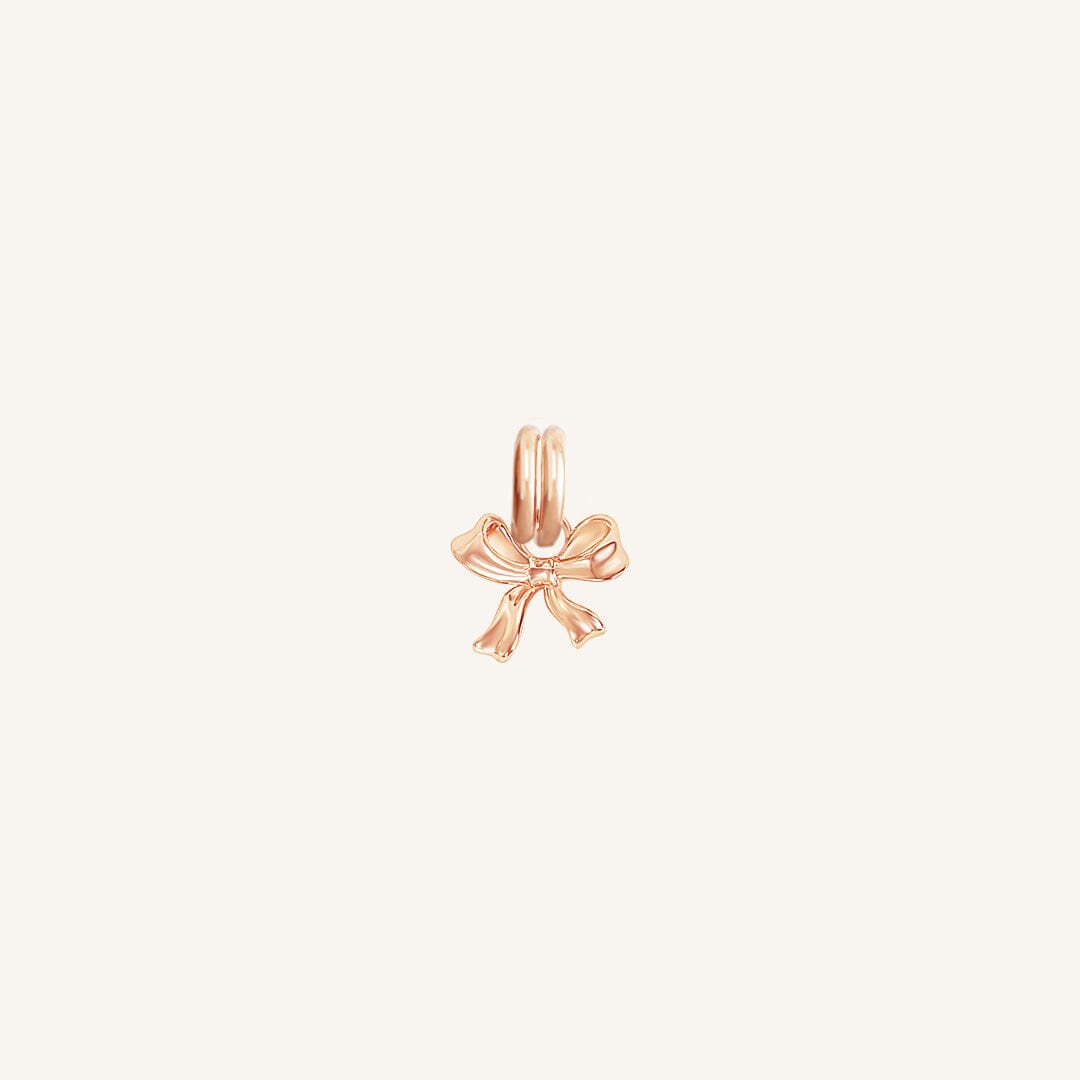 A small rose bow charm with a loop on top for attachment, displayed on a white background.