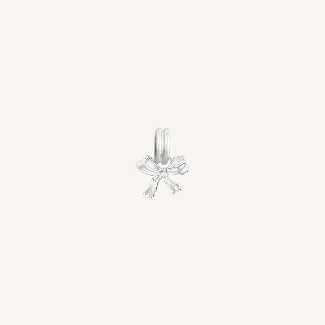 A small silver bow charm with a loop on top for attachment, displayed on a white background.
