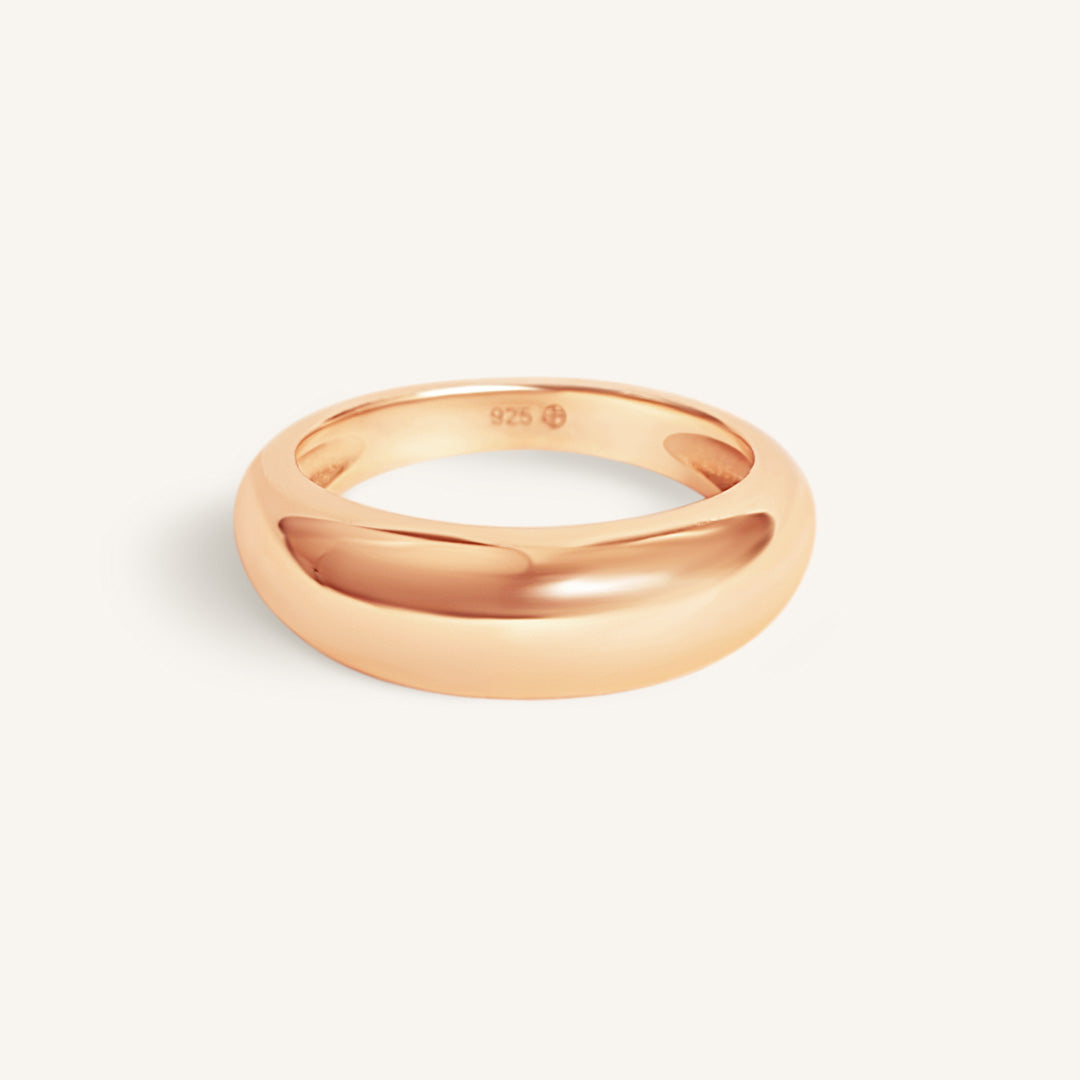 Rose gold ring on a light beige background