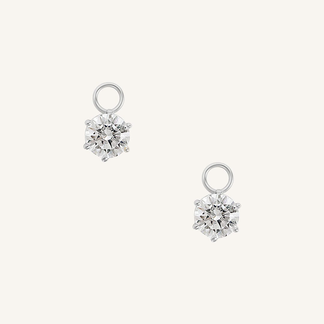 A set of two hoop charms with silver metal tone, designed to be attached to earrings.