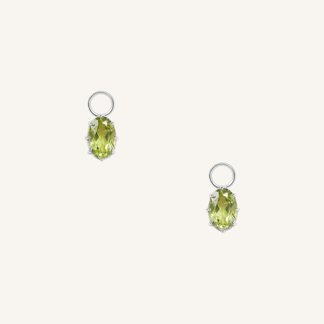 A set of two silver hoop charms with olive green stones, isolated on a white background.