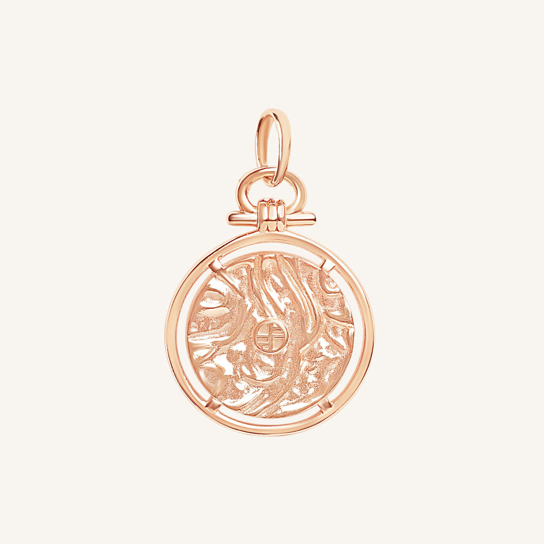 Rose gold pendant with intricate design on a white background