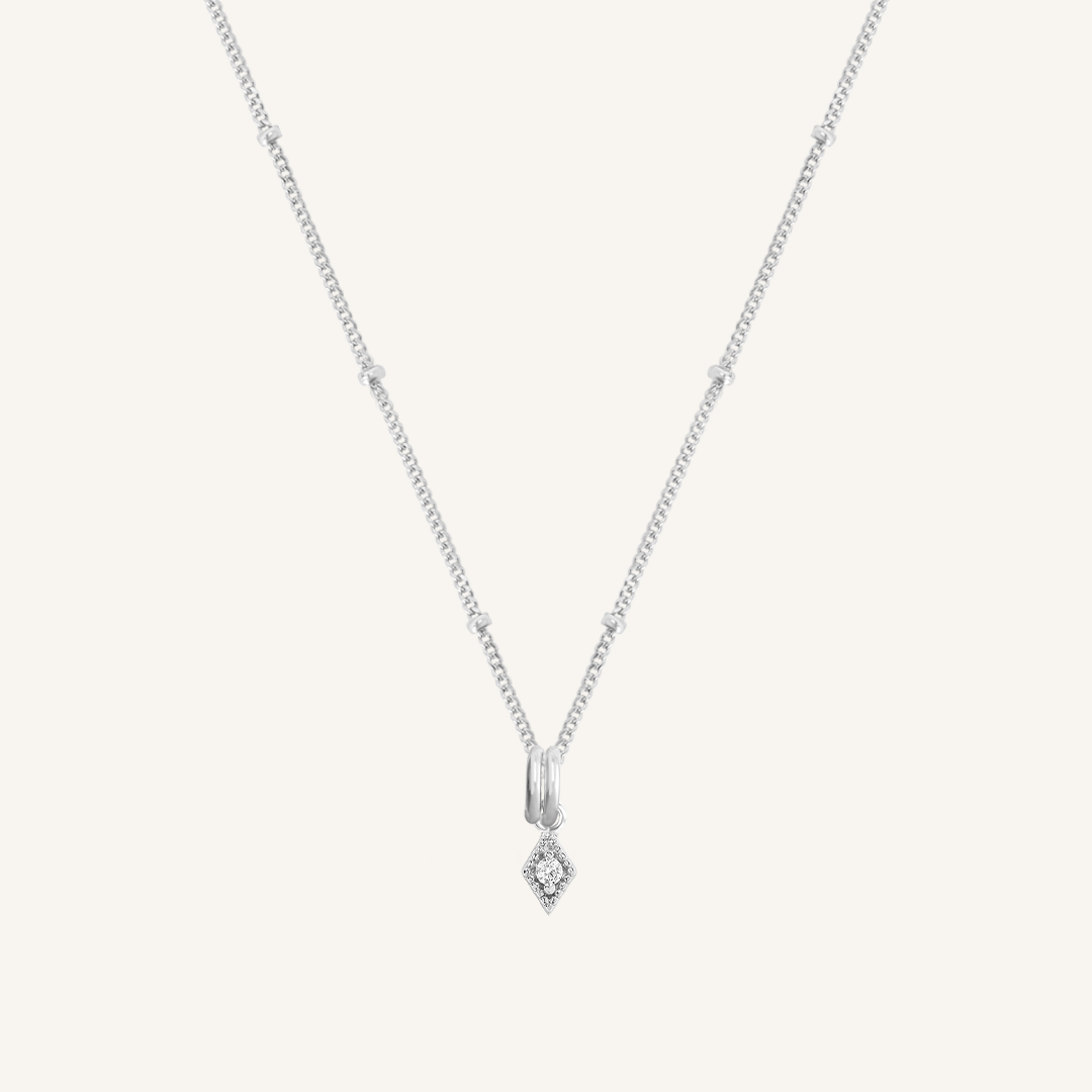 A delicate necklace featuring a small diamond charm pendant suspended from a silver-tone chain.