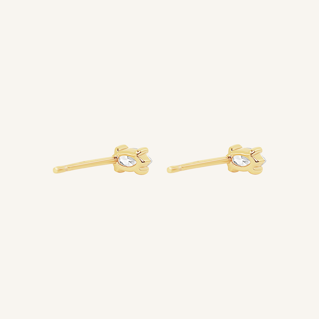 A pair of stud earrings with clear cubic zirconia set in gold metal, presented against a white background.