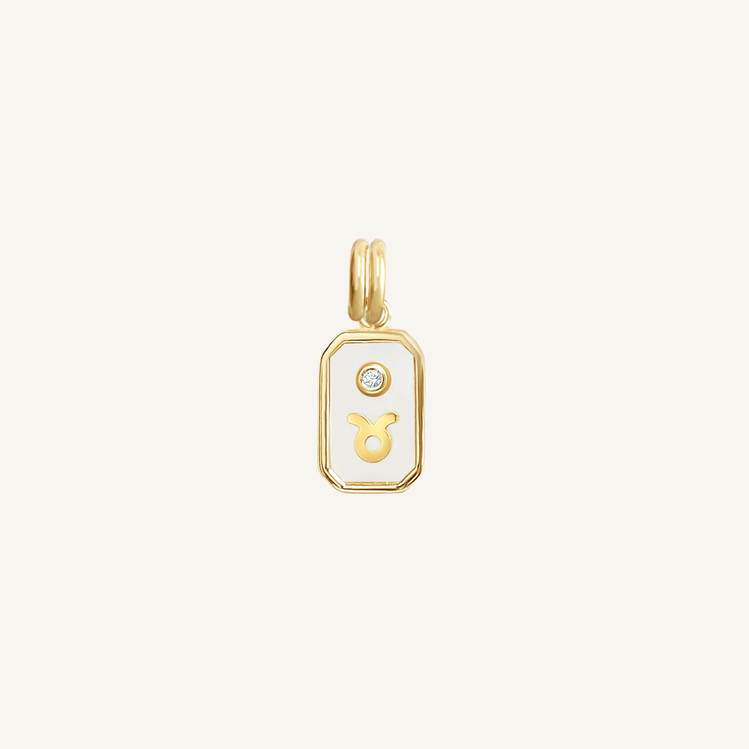 A gold iridescent zodiac charm representing the Taurus sign, with a loop for attachment