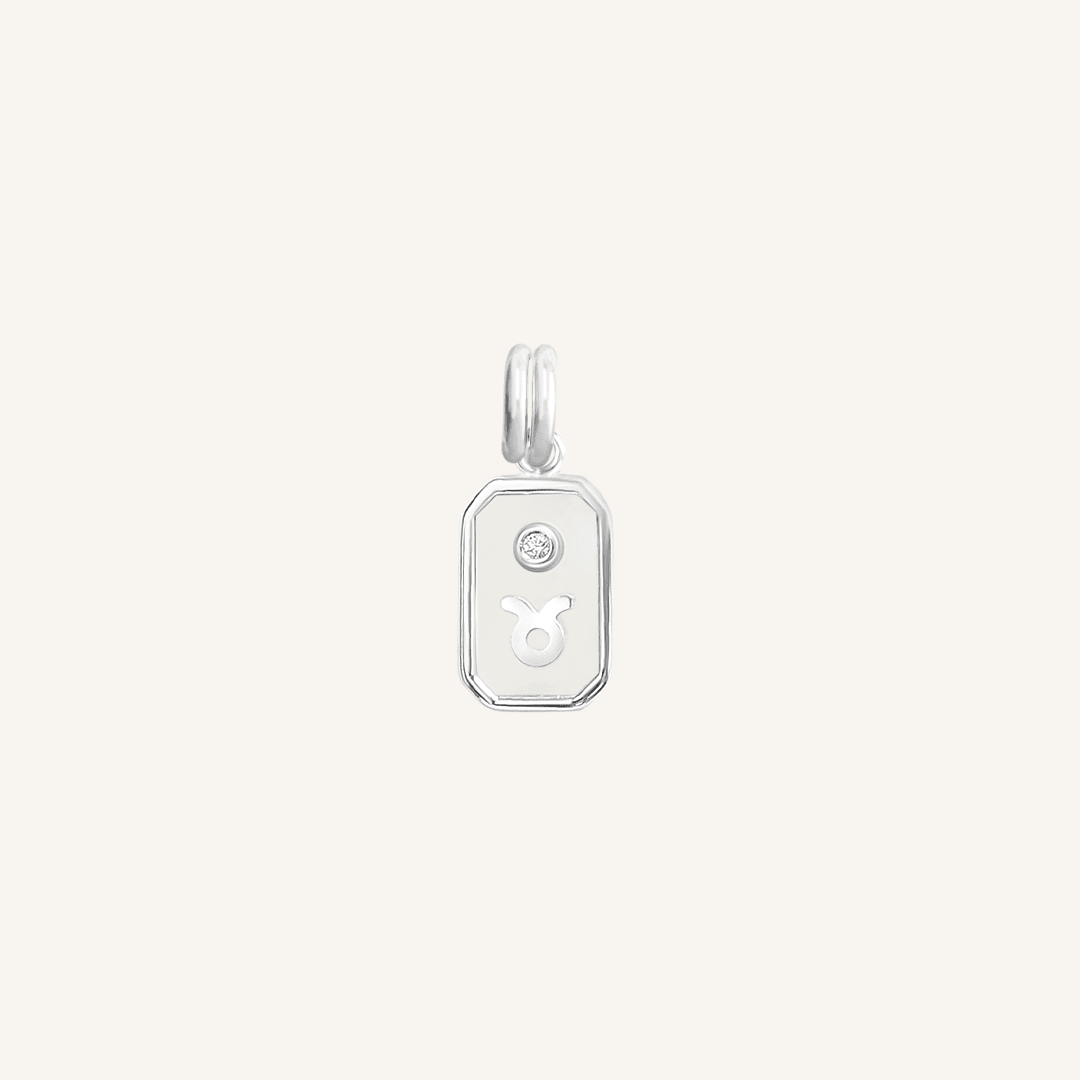 A silver iridescent zodiac charm representing the Taurus sign, with a loop for attachment
