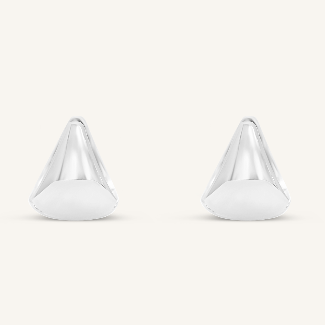 A pair of silver huggie hoop earrings on a white background.