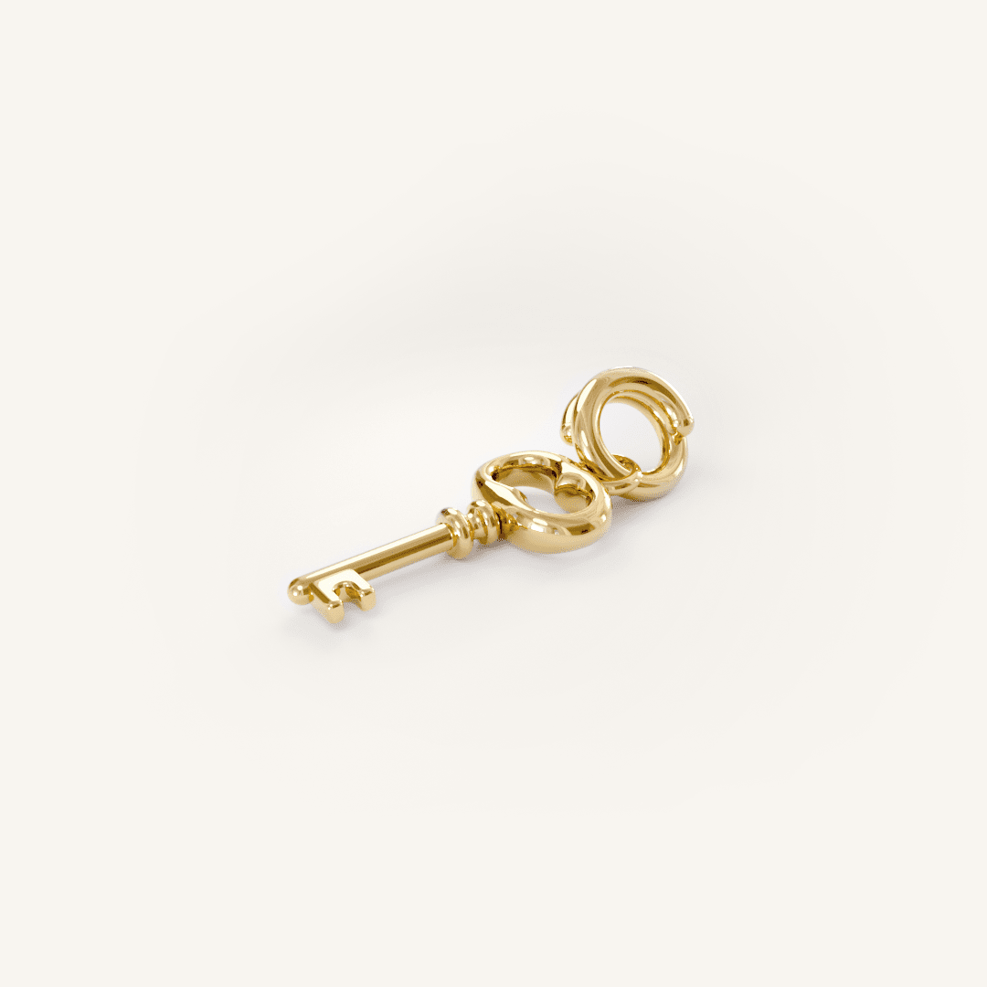 A gold key charm on a plain background