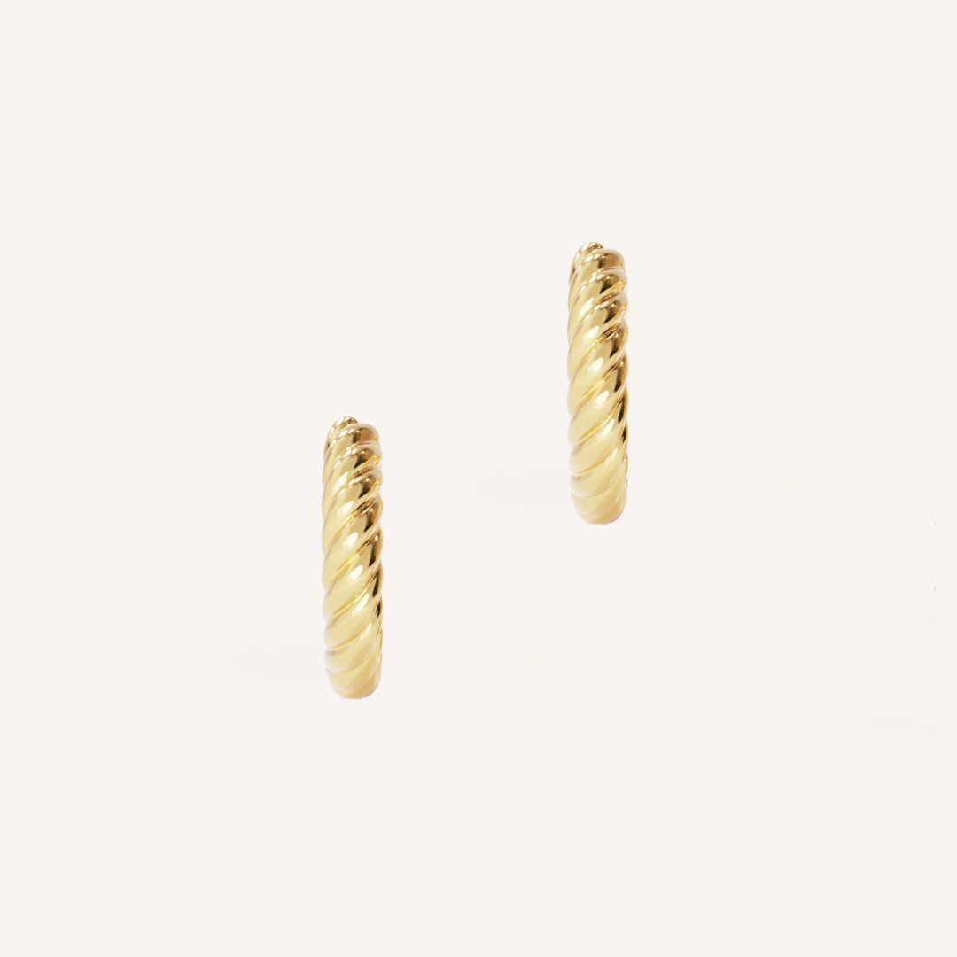 gold delicate hoops with a twist design on white background