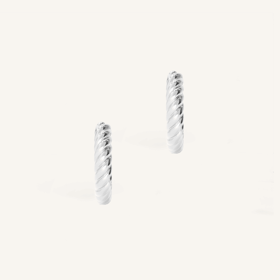 silver delicate hoops with a twist design on white background