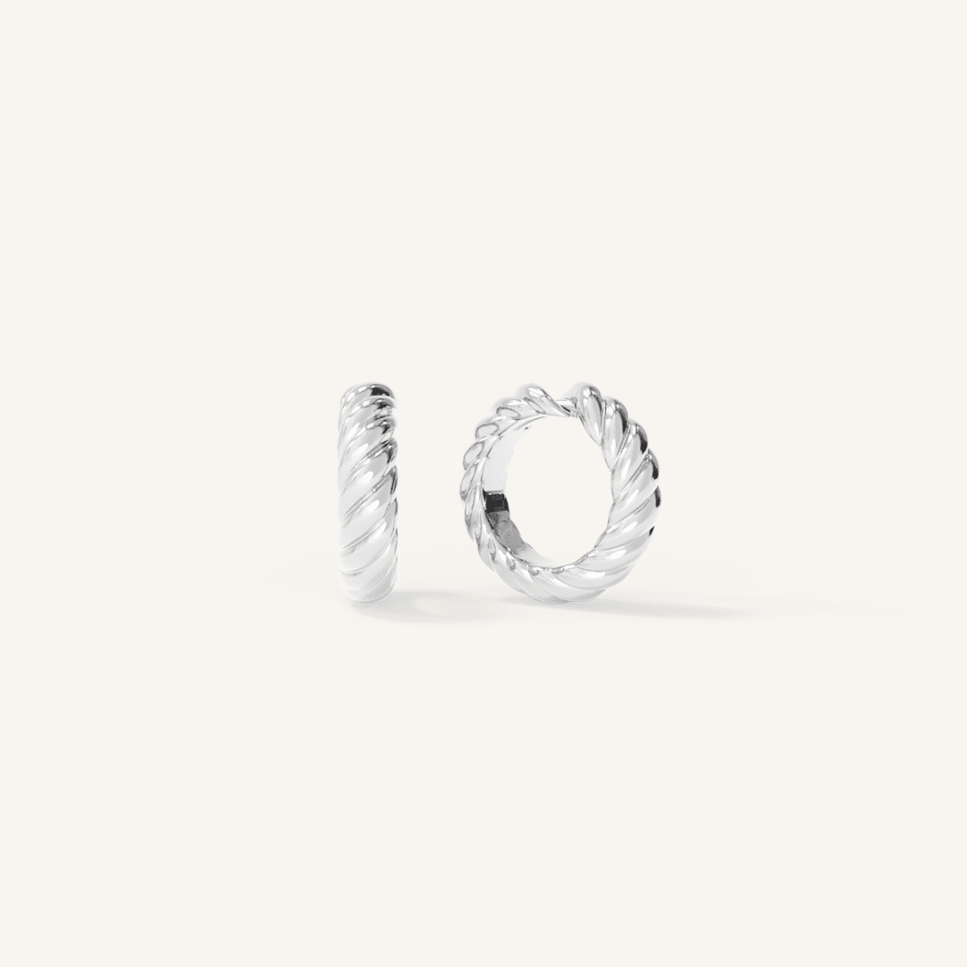 silver delicate huggies with a twist design on white background