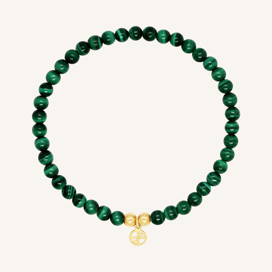 A beaded bracelet made of green malachite stones and metal beads with a gold-colored charm, displayed on a white background.