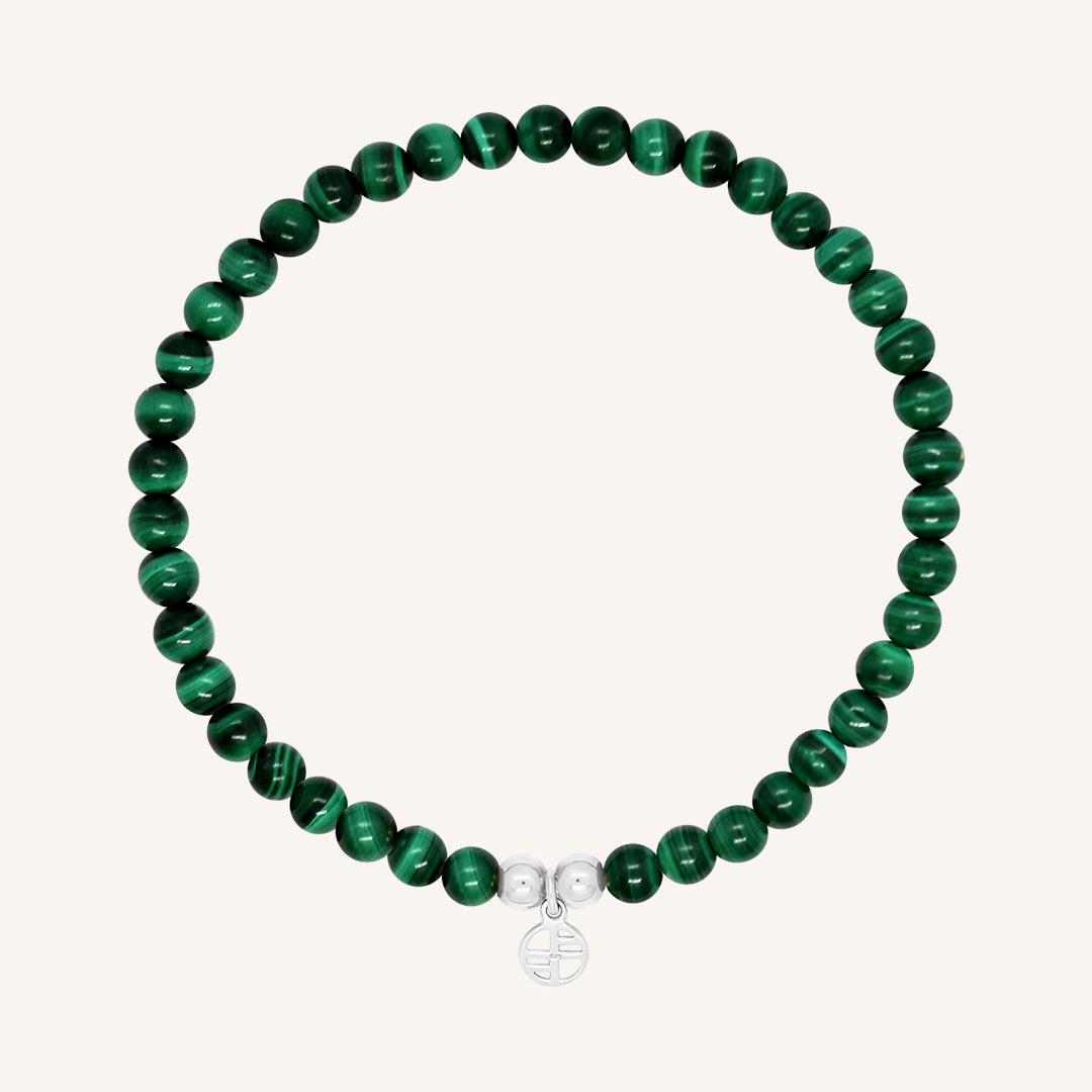 A beaded bracelet made of green malachite stones and metal beads with a silver-colored charm, displayed on a white background.