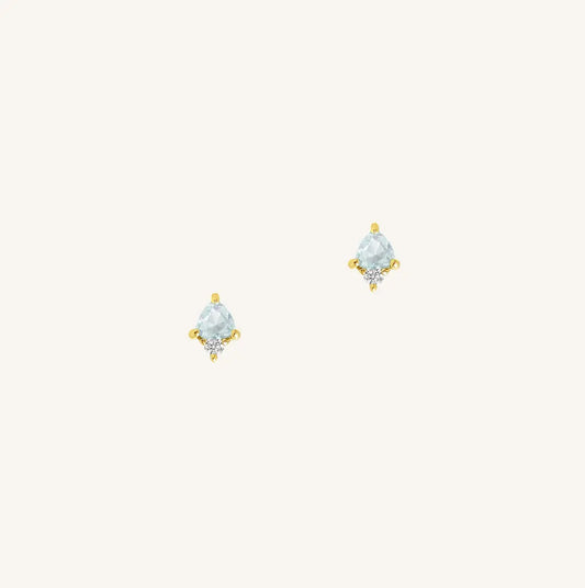A gold pair of stud earrings featuring a blue cubic zirconia, representing March.