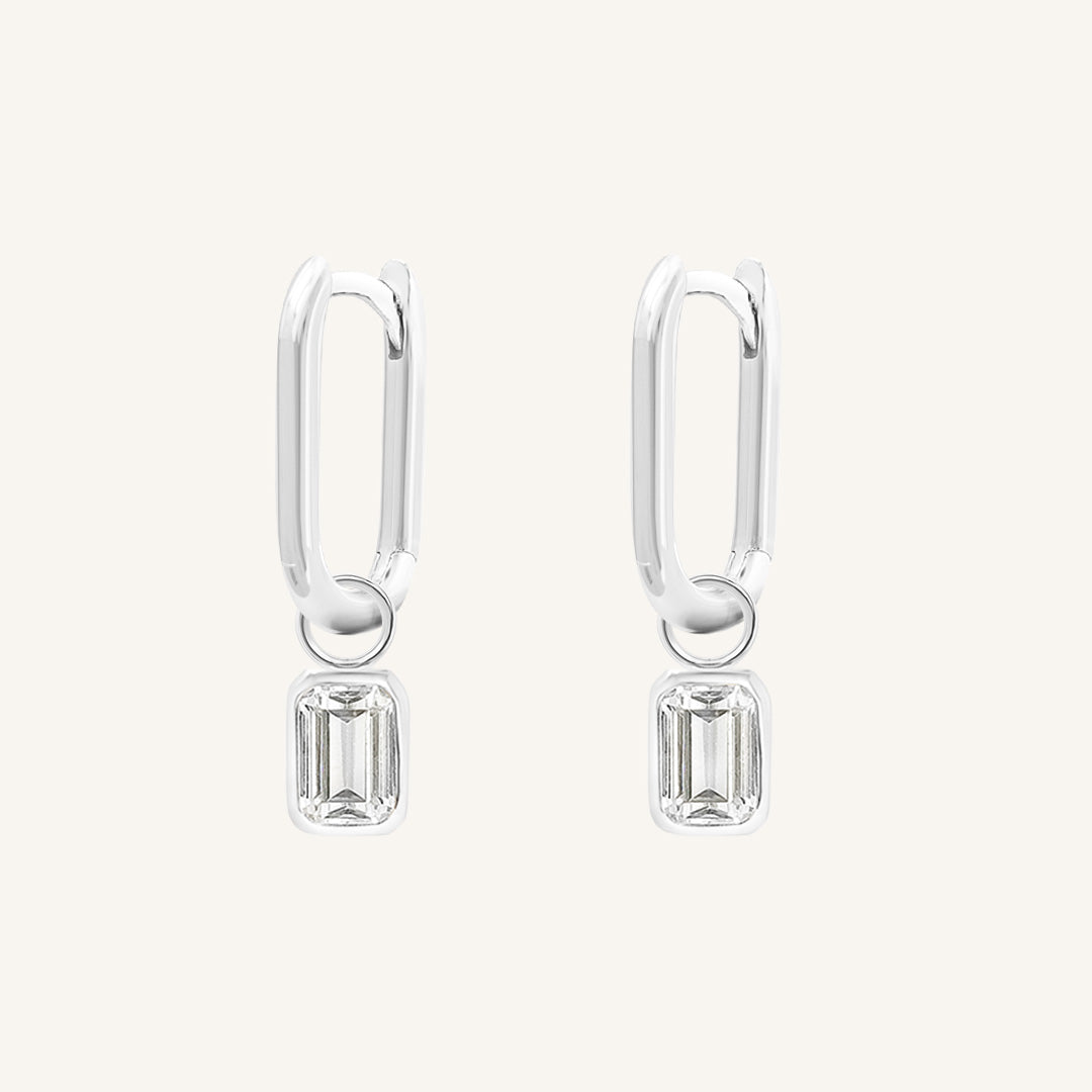 A rectangular pair of hoop charms with cubic zirconias attached to hoops