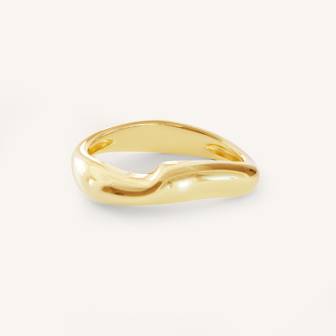 A gold-coloured ring with an irregular, smooth shape on a white background