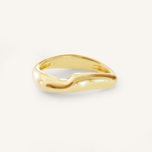 A gold-coloured ring with an irregular, smooth shape on a white background