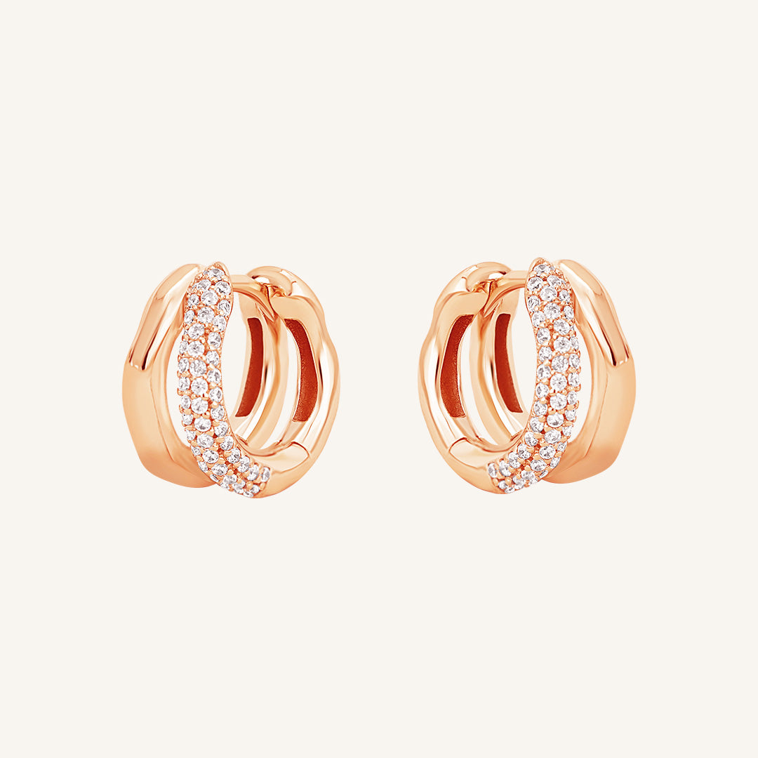 A pair of gold-colored hoop earrings with a huggie design, featuring a layered look.