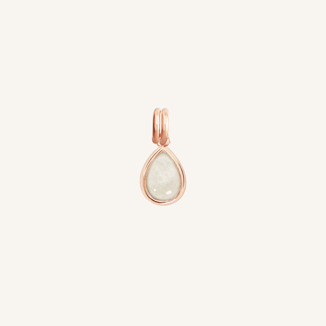 A rose gold charm with a teardrop-shaped moonstone