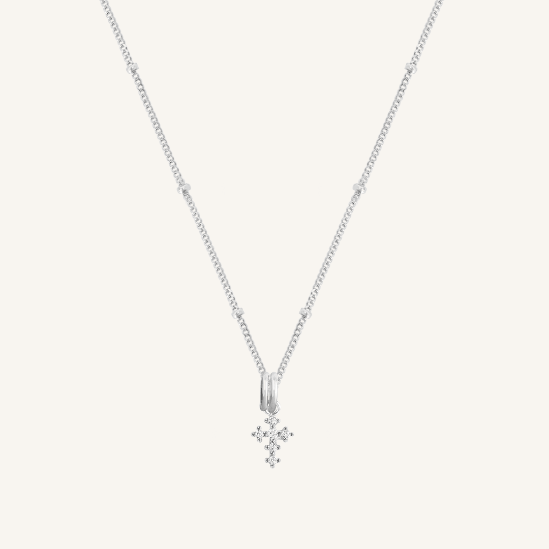 A silver-tone Nurture Cross Charm Pendant Necklace with a vintage cross shape on a chain.
