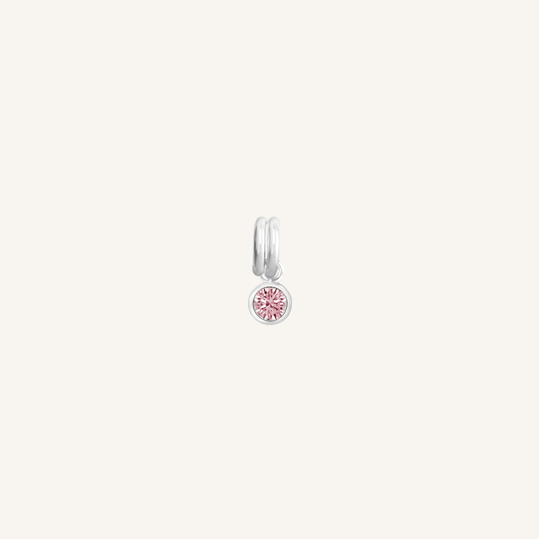 A round silver charm with a pink birthstone, designed for October birthdays.