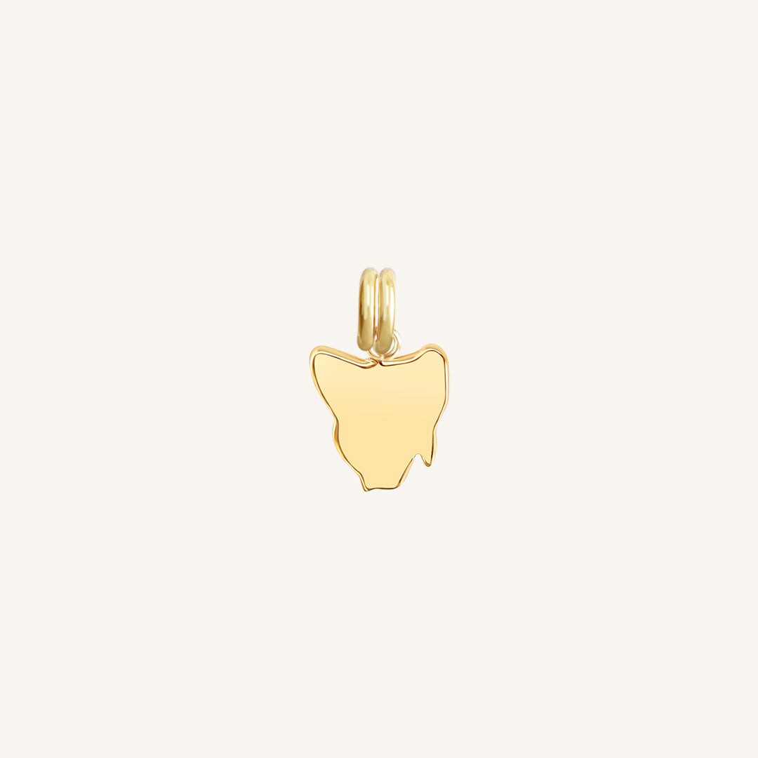 A gold-colored charm in the shape Tasmania