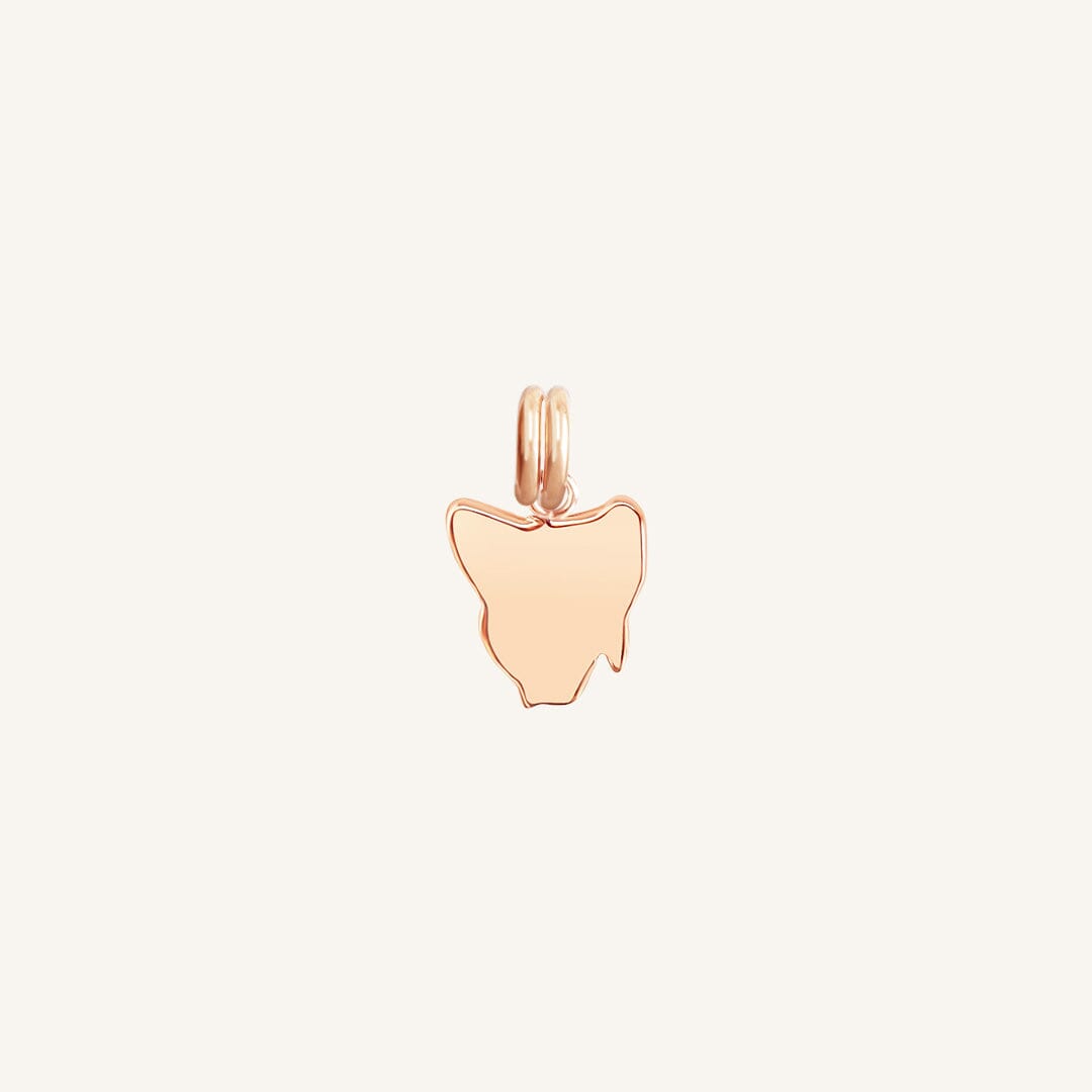 A rose-colored charm in the shape Tasmania