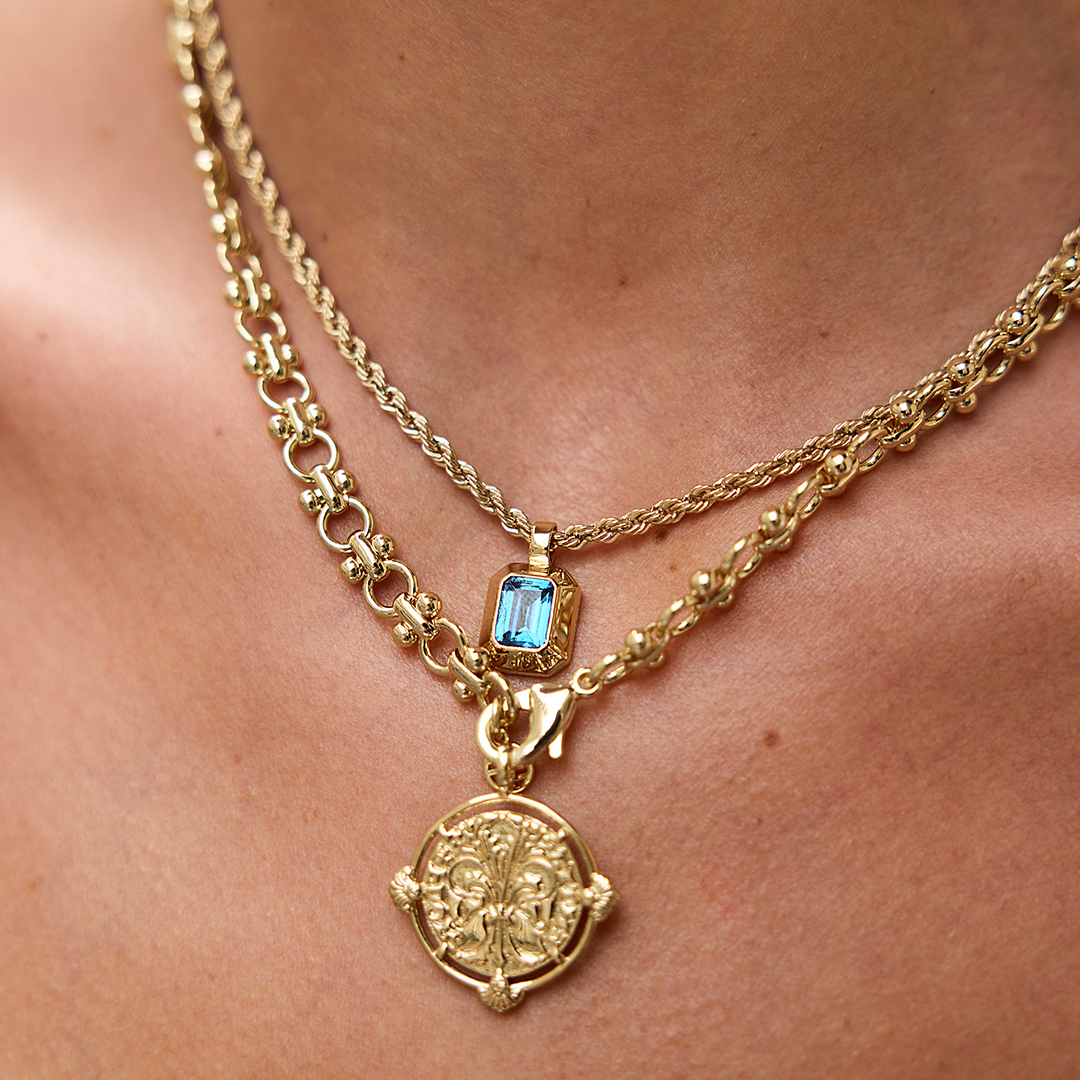 Gold charm with Blue emerald cut cubic zirconia bezel set Inspired by the halls of Versailles on neck