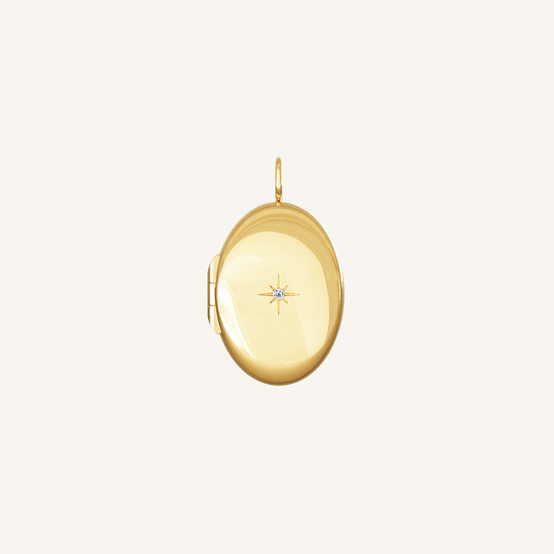 Front of gold oval locket, featuring a cubic zirconia in the middle