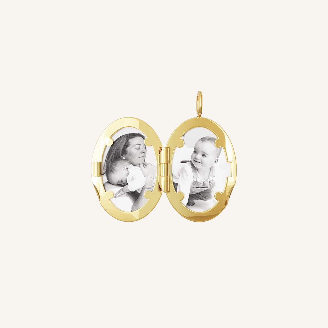 An oval-shaped photo locket with a gold metal tone, open to display two photographs