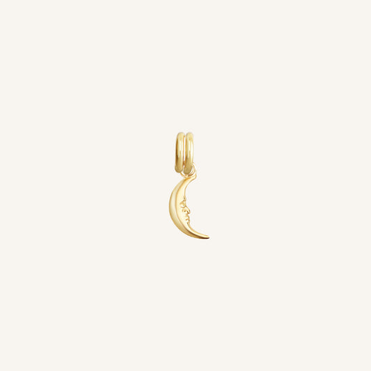 A gold charm in the shape of a crescent moon