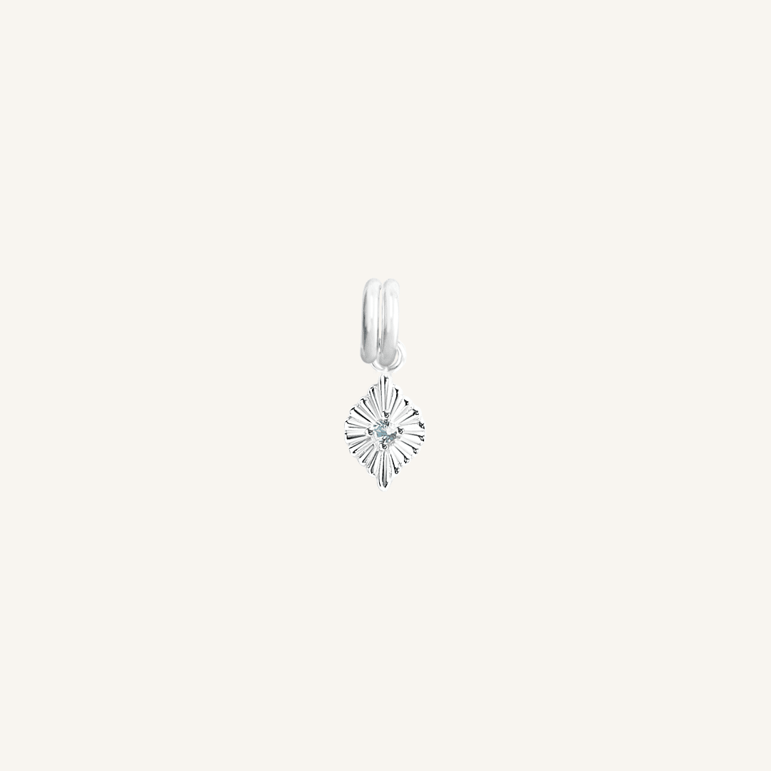 A silver birthstone charm with a blue cubic zirconia representing the month of March.