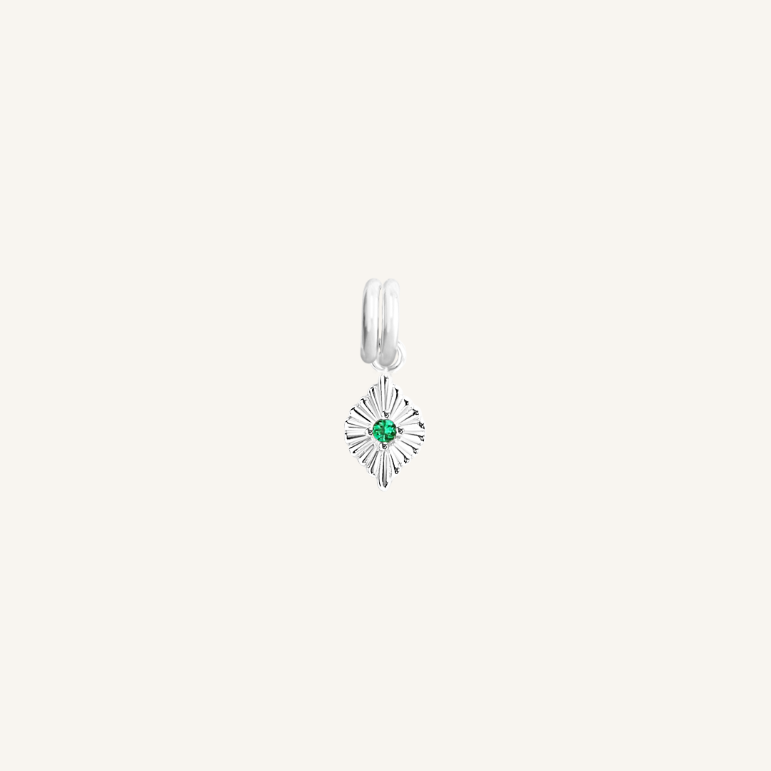 A silver charm with a green cubic zirconia, resembling a May birthstone.