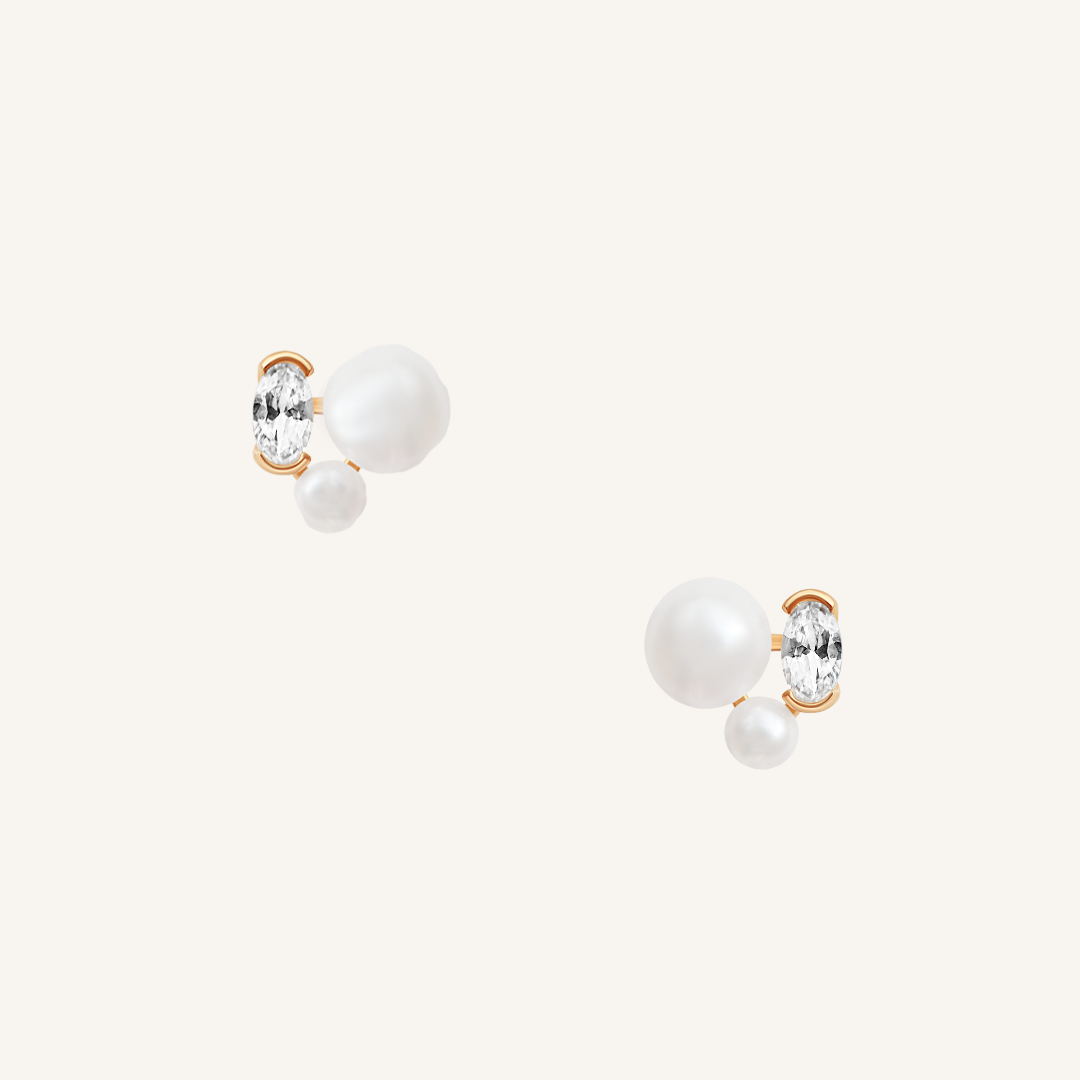 A pair of pearl stud earrings with gold accents on a white background.