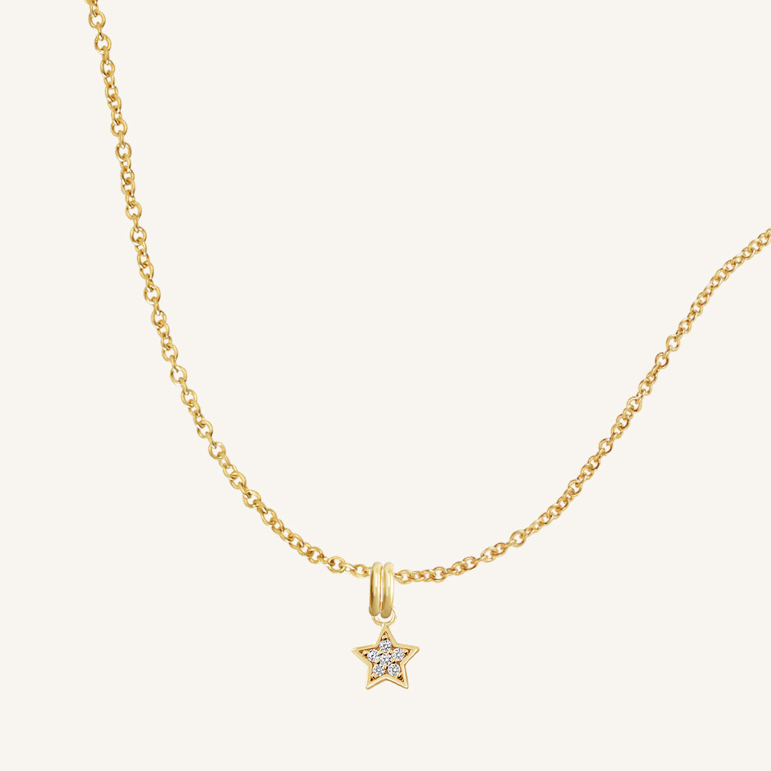 A gold necklace featuring a star-shaped charm pendant with cubic zirconias in the centre
