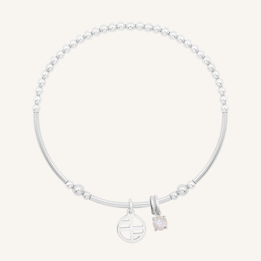 A silver charm bracelet featuring a beaded design with a small circular charm and a moonstone charm.