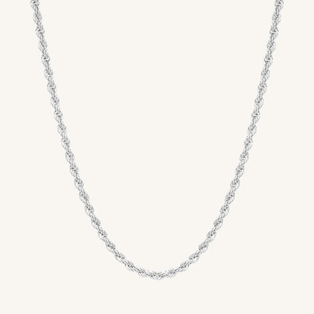 A silver rope chain necklace on a plain background.