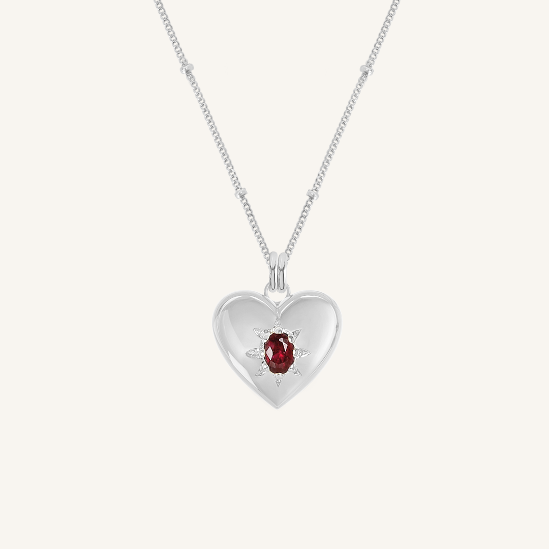 silver heart shaped charm with deep red oval cubic zirconia on bobble chain on white background