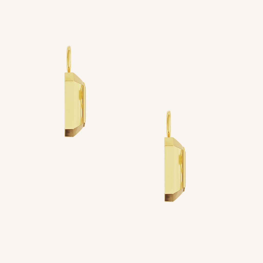 rectangular gold hoop charms with Blue emerald cut cubic zirconias bezel set on white background side profile