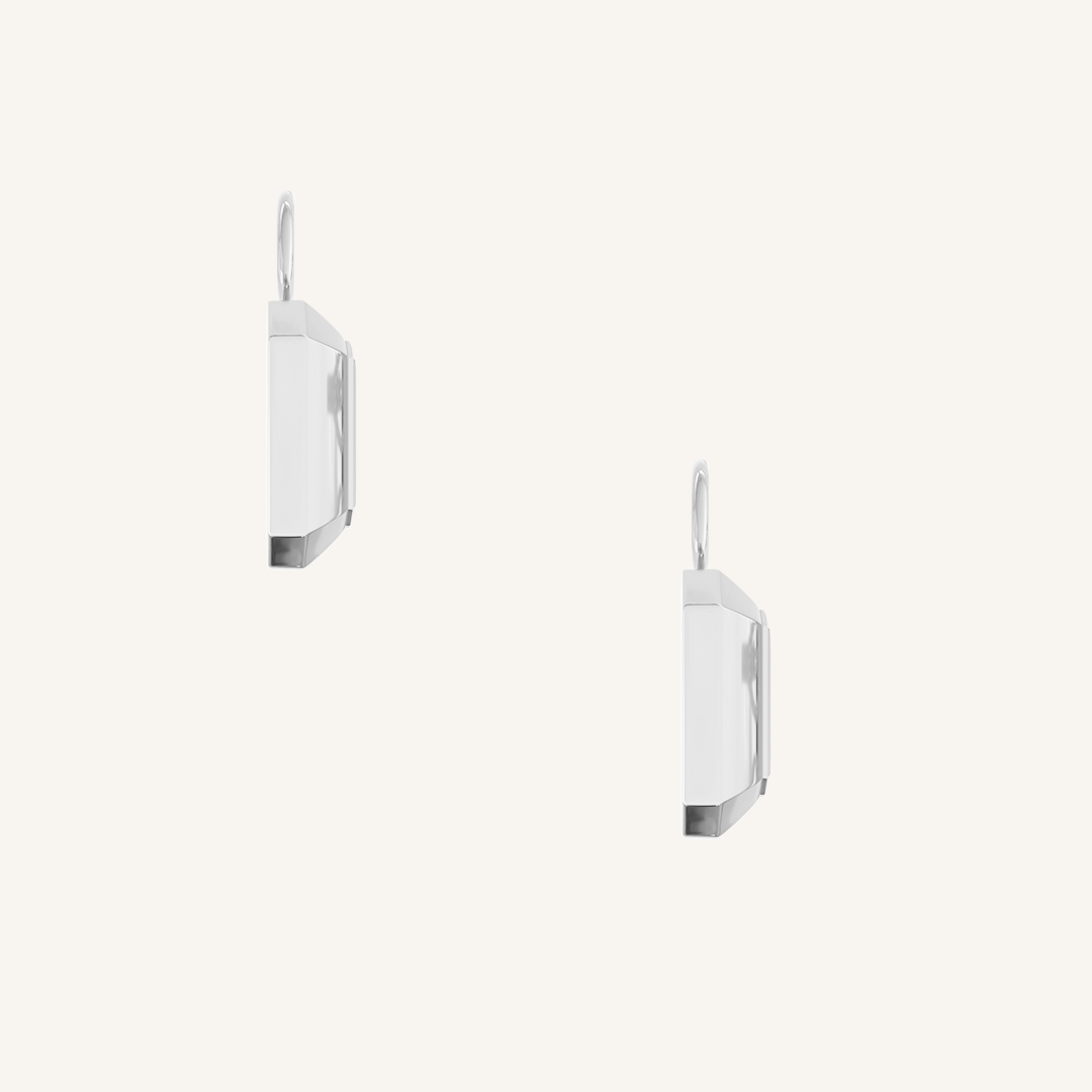 rectangular silver hoop charms with Blue emerald cut cubic zirconias bezel set on white background side profile