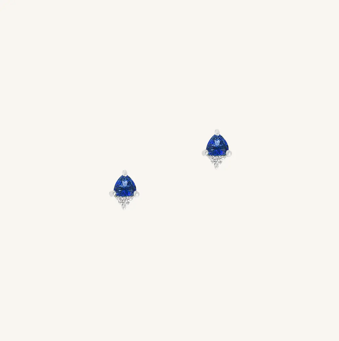 A silver pair of stud earrings featuring a blue cubic zirconia, representing September.