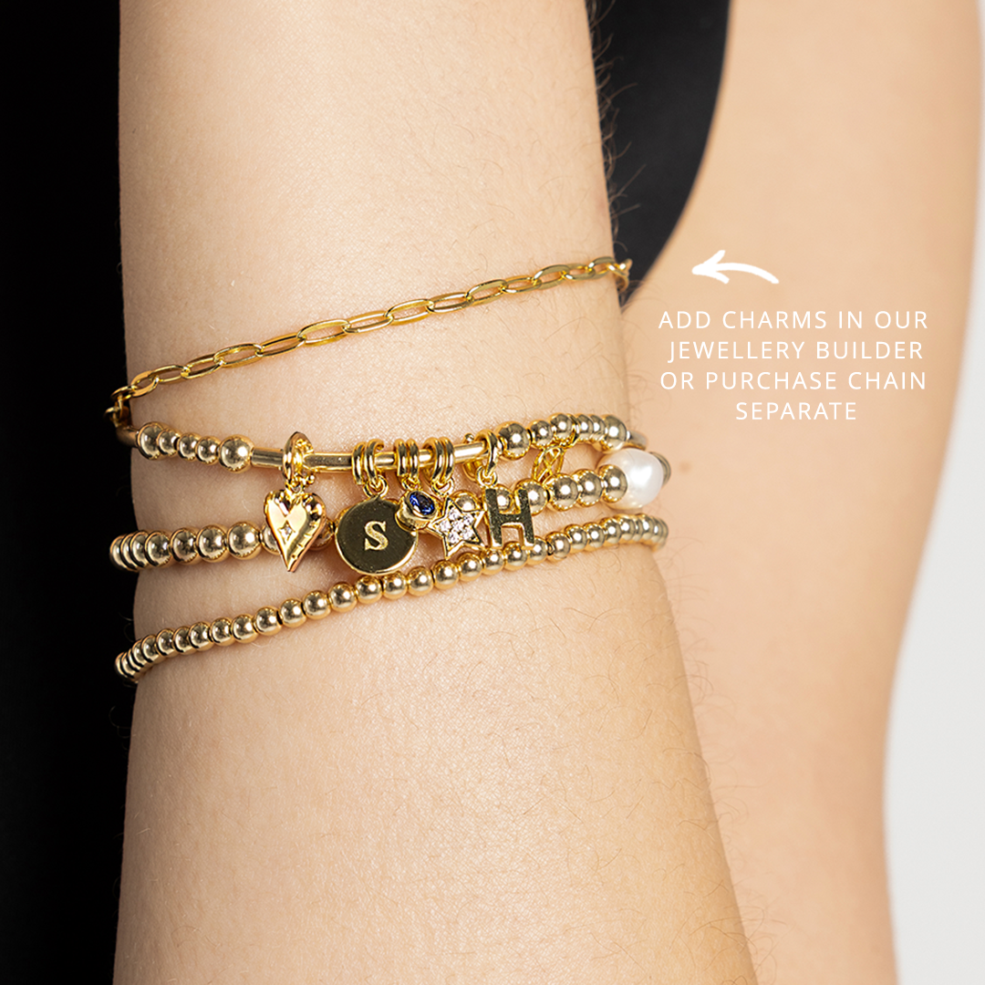 Story chain bracelet stacked with other bracelets on wrist