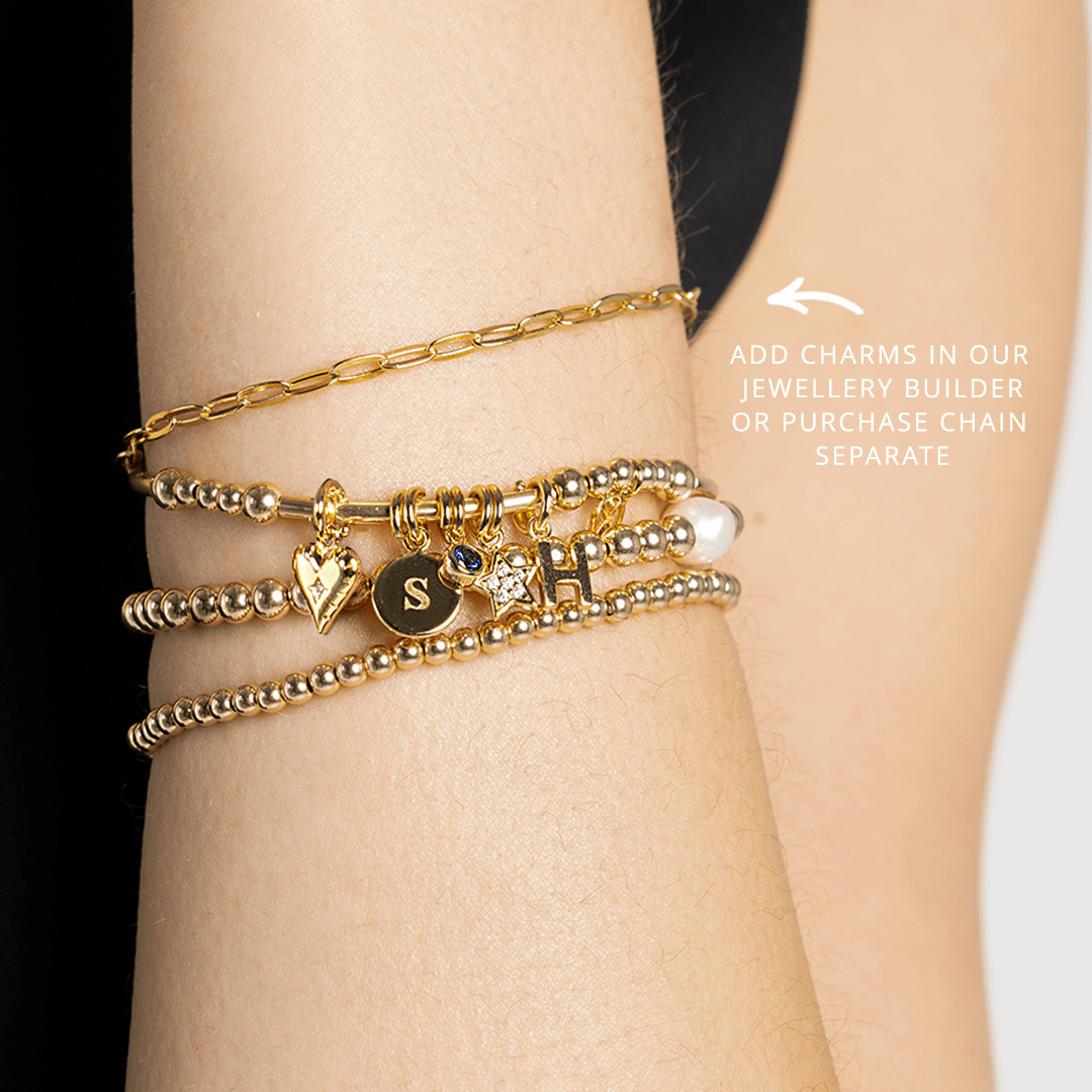Story chain bracelet stacked with other bracelets on wrist