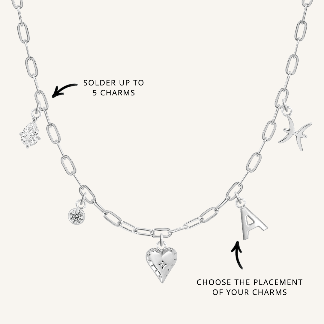 A silver chain necklace with paperclip links and multiple charms, showcasing where to solder charms and the option to choose the placement of the charms.