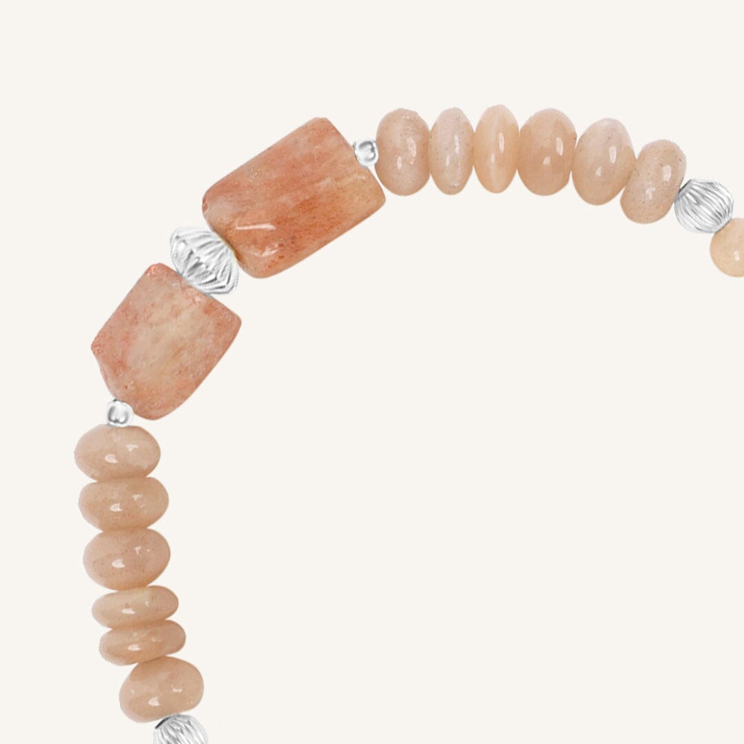 Bracelet with pink beads and silver accents on a white background
