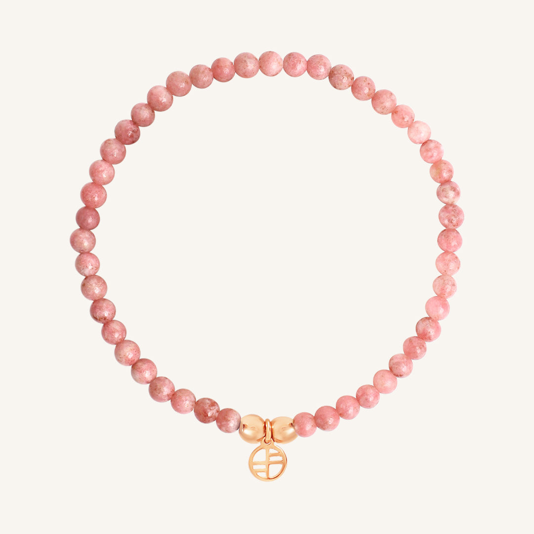 Pink beaded bracelet with a rose charm on a white background