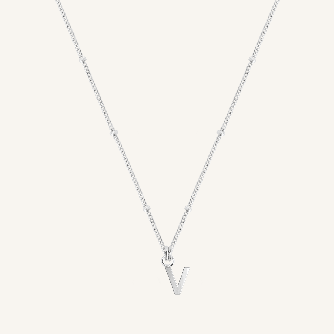 Silver necklace with a 'V' pendant on a light gray background
