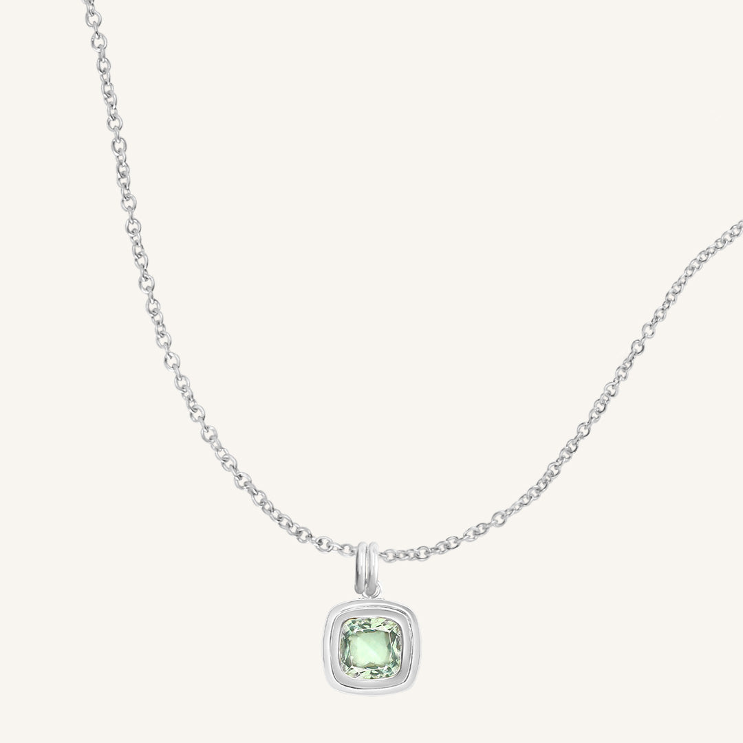 Necklace with a green gemstone pendant on a white background