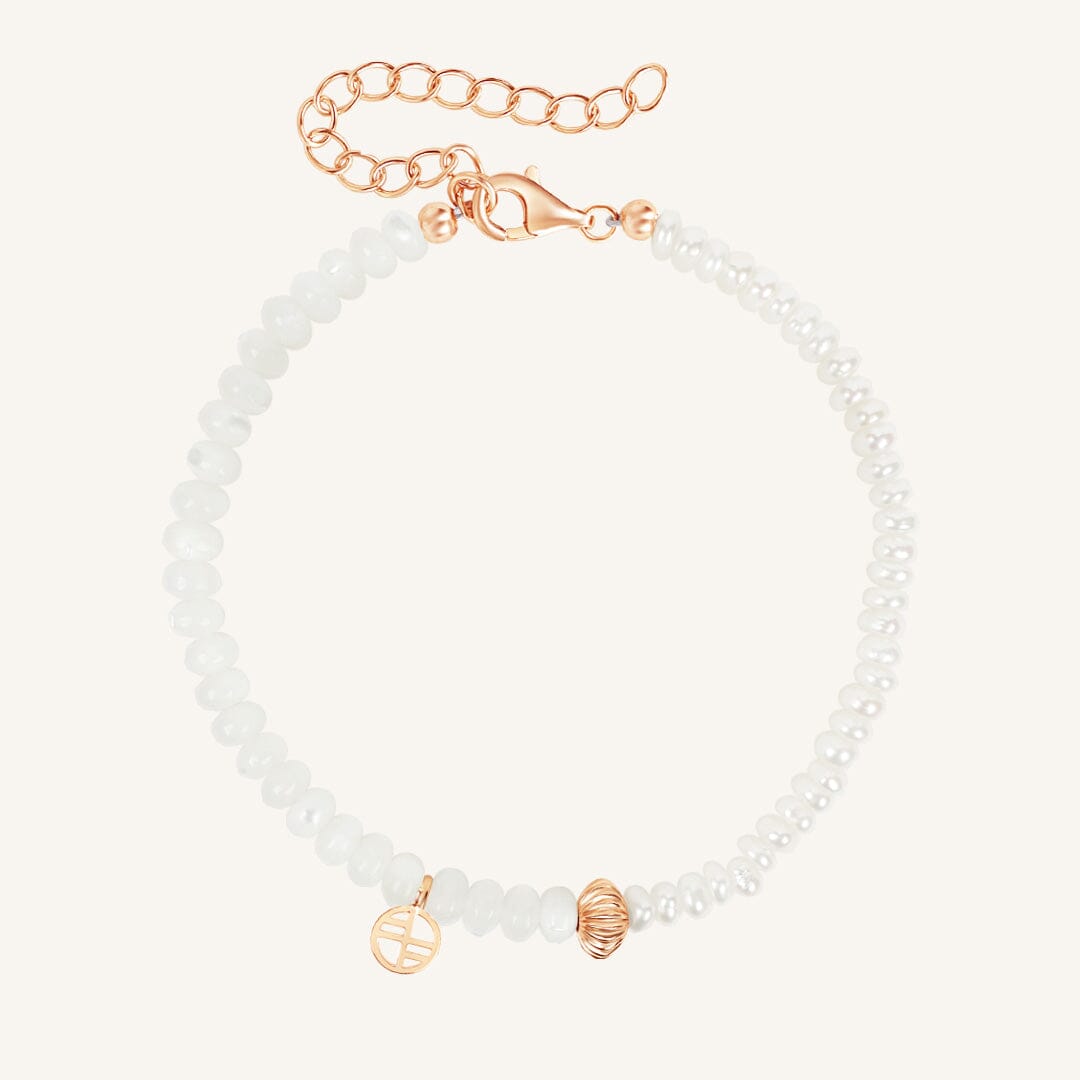 White beaded bracelet with gold accents on a white background